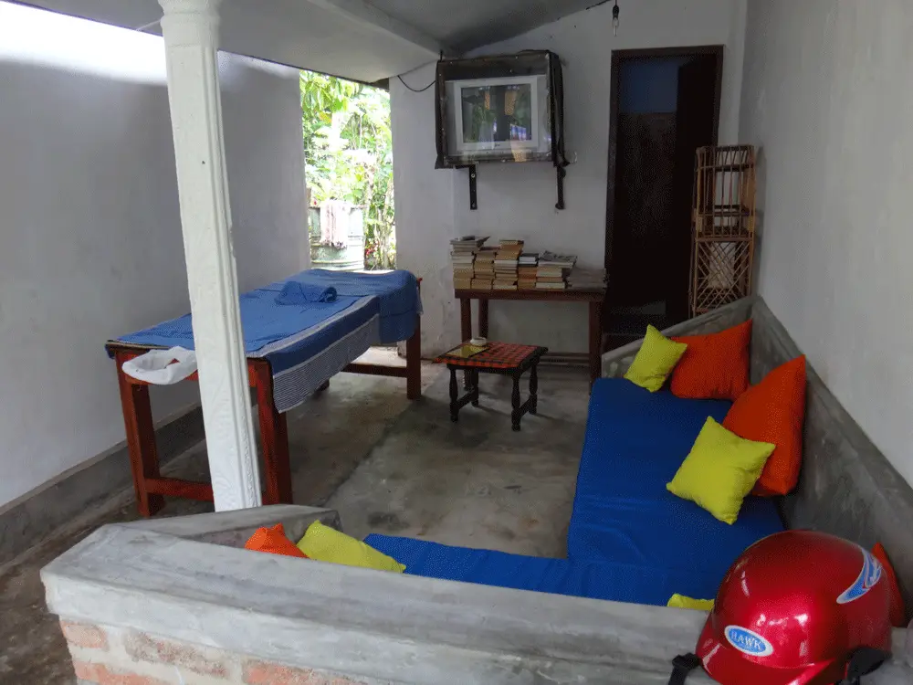 The chill-out area at Surfing Life with blue cushions, colourful pillows and a shelf of books