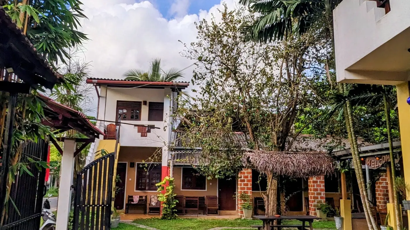 Sunny garden and buildings at Surfing Life Guest House under a blue sky